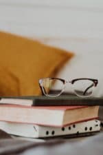 club master eyeglasses on pile of three books